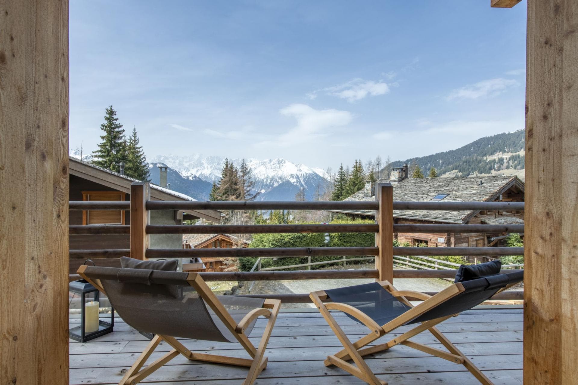 Balcony with wooden deck chairs and snow-capped mountain views