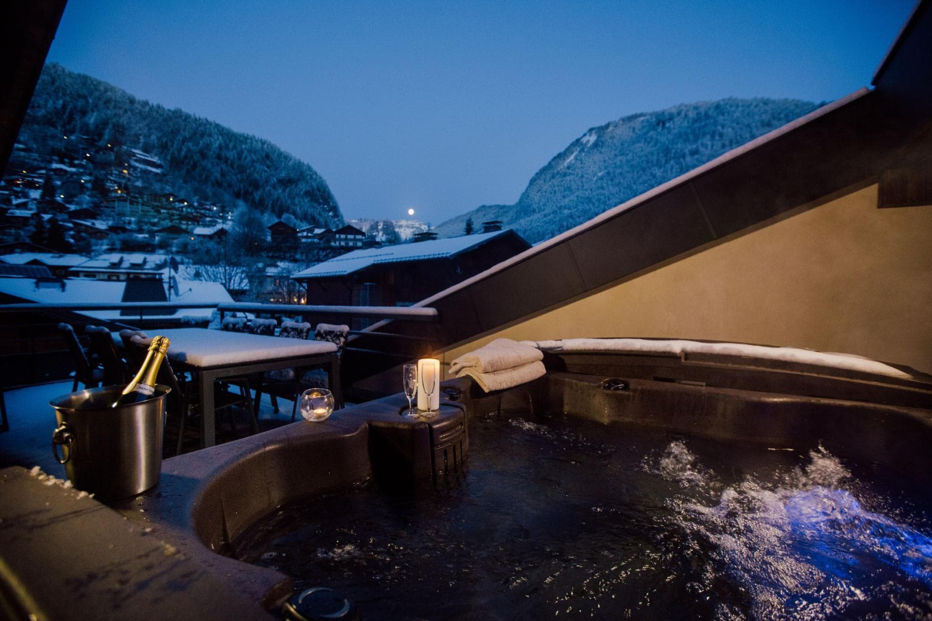 Private terrace hot tub with mountain views and outdoor dining table