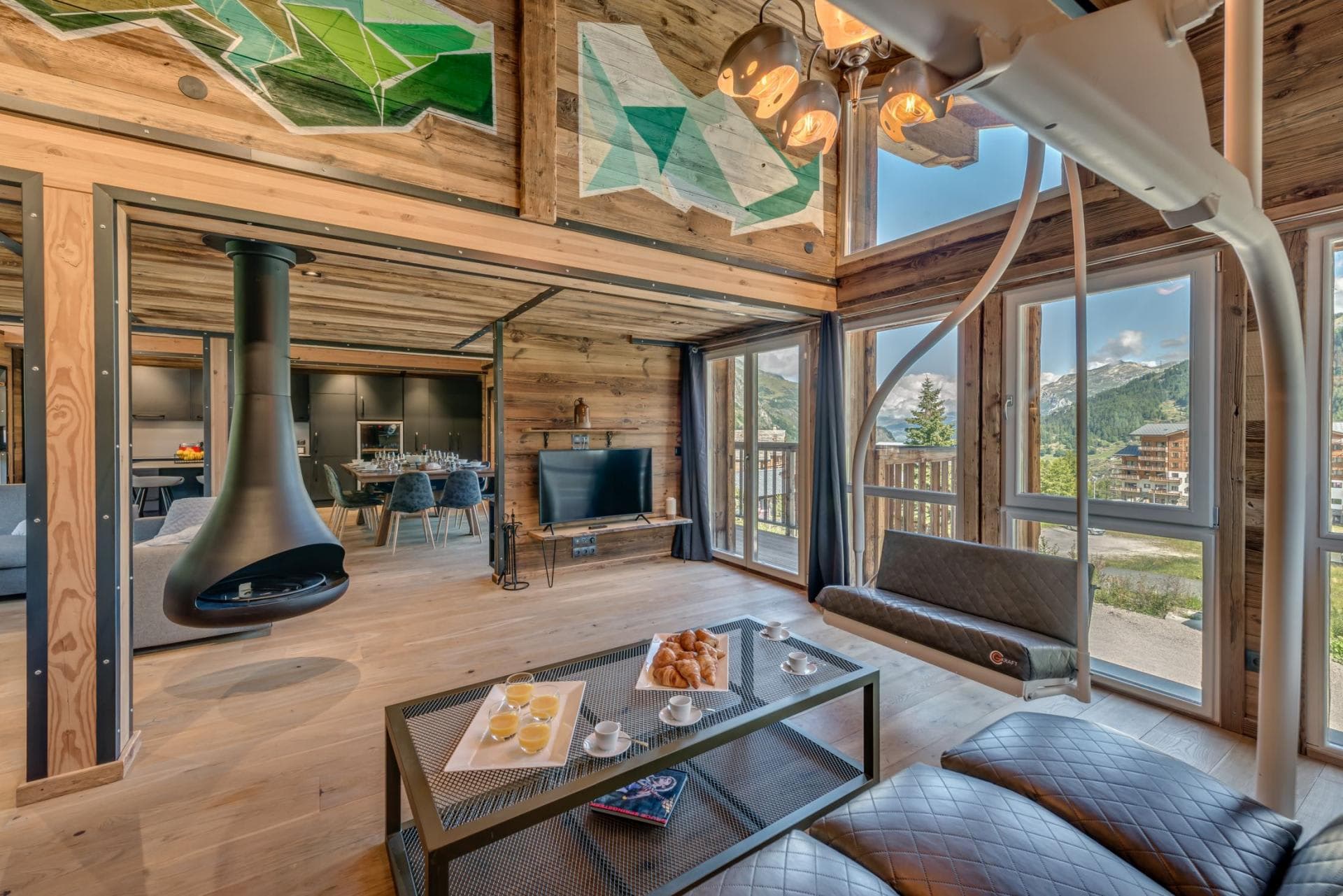 Living area featuring suspended fireplace and repurposed ski lift bench seating