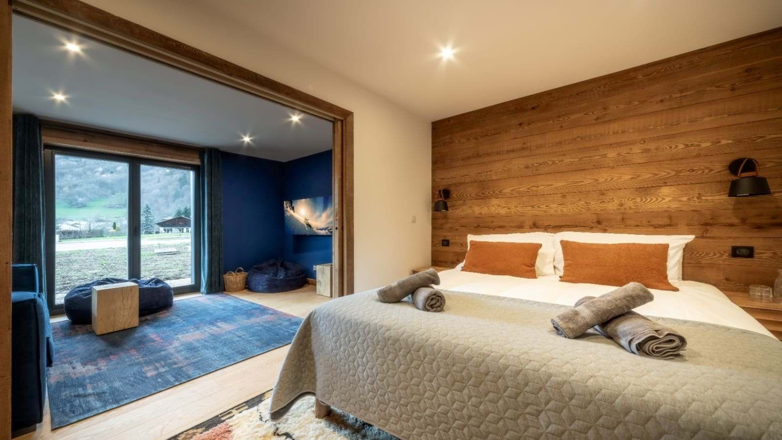 King bedroom with wood paneling and attached media snug