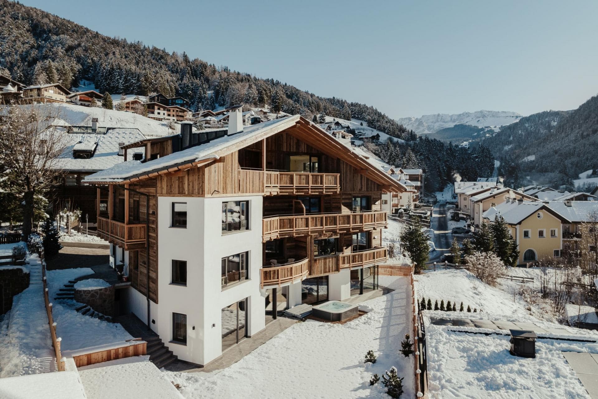 Chalet exterior with ground-floor terrace, hot tub, and mountain valley views