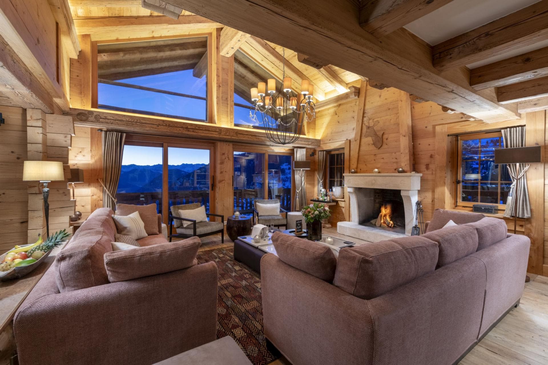 Living area with wood-burning fireplace and mountain-view floor-to-ceiling windows