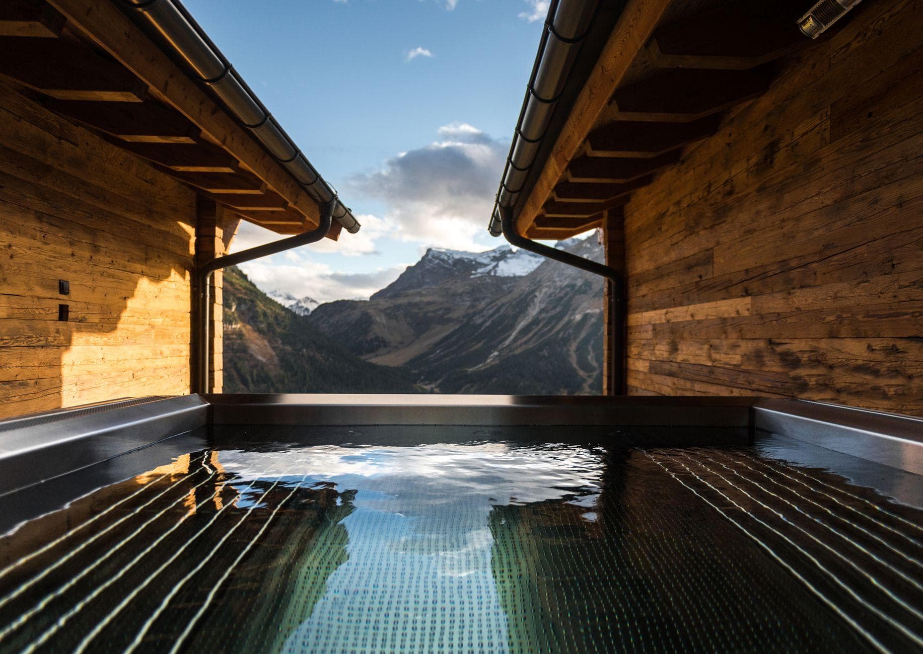 Stainless steel infinity pool with panoramic Alpine mountain views