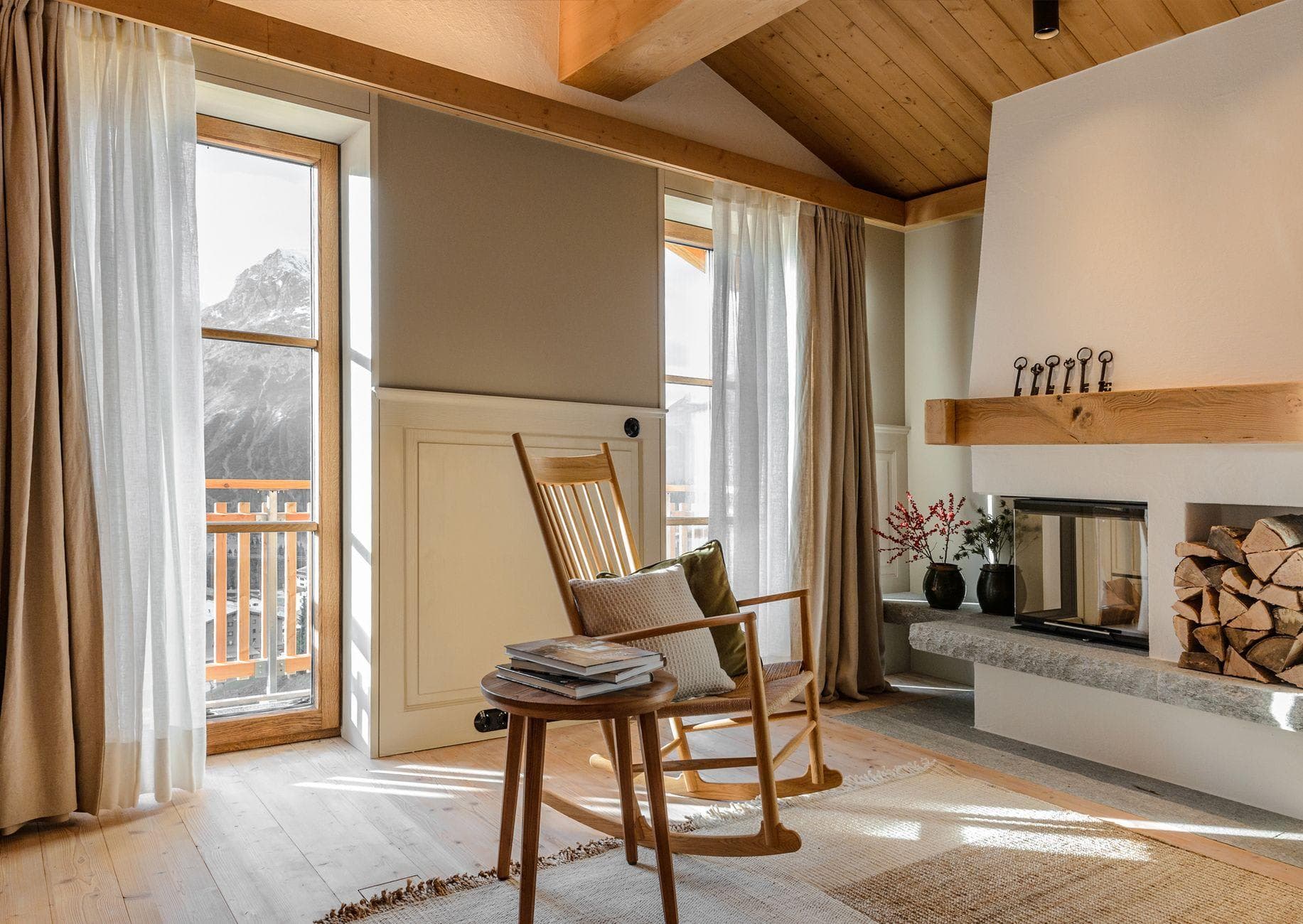 Seating area with wood-burning fireplace and mountain-view balcony
