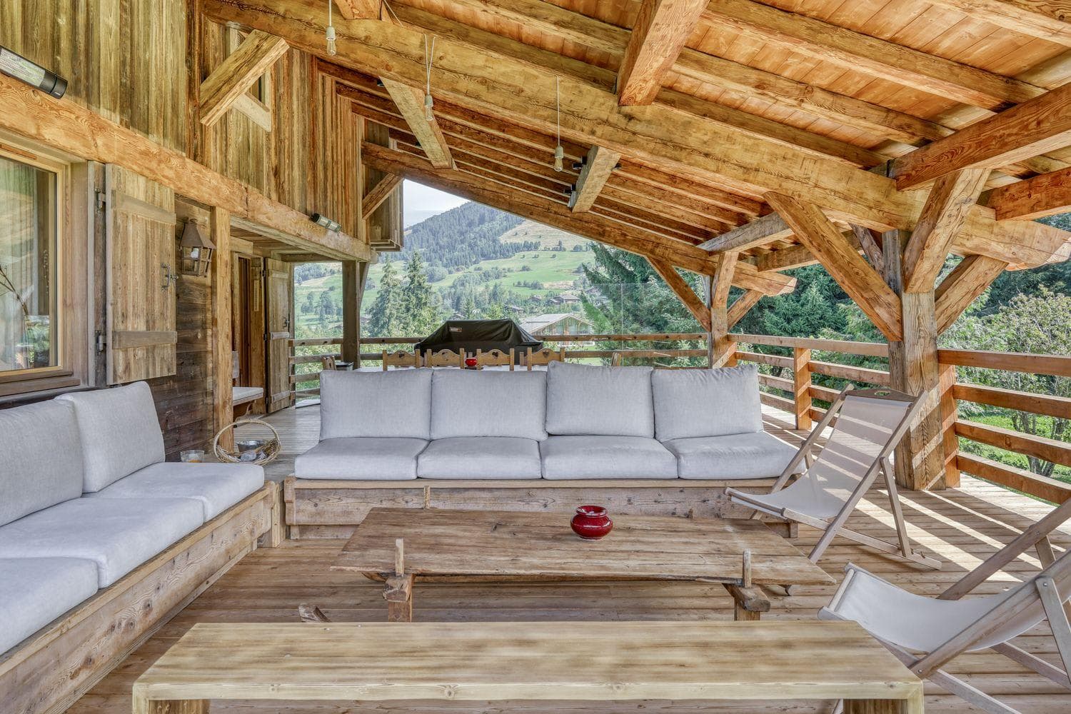 Covered balcony with sectional seating, gas grill, and mountain valley views