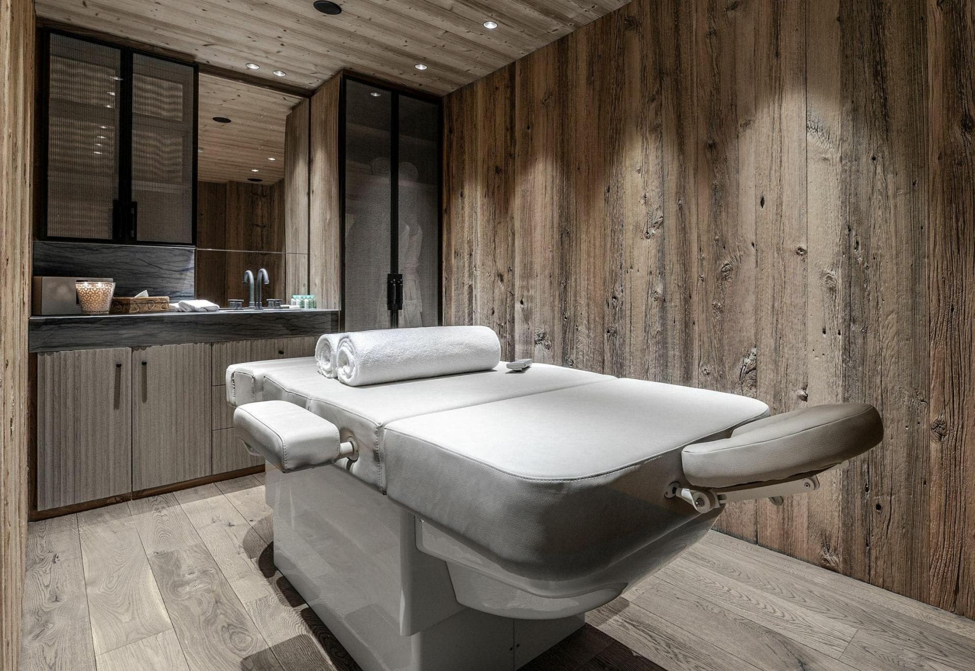 Private spa room with massage table and reclaimed wood paneling