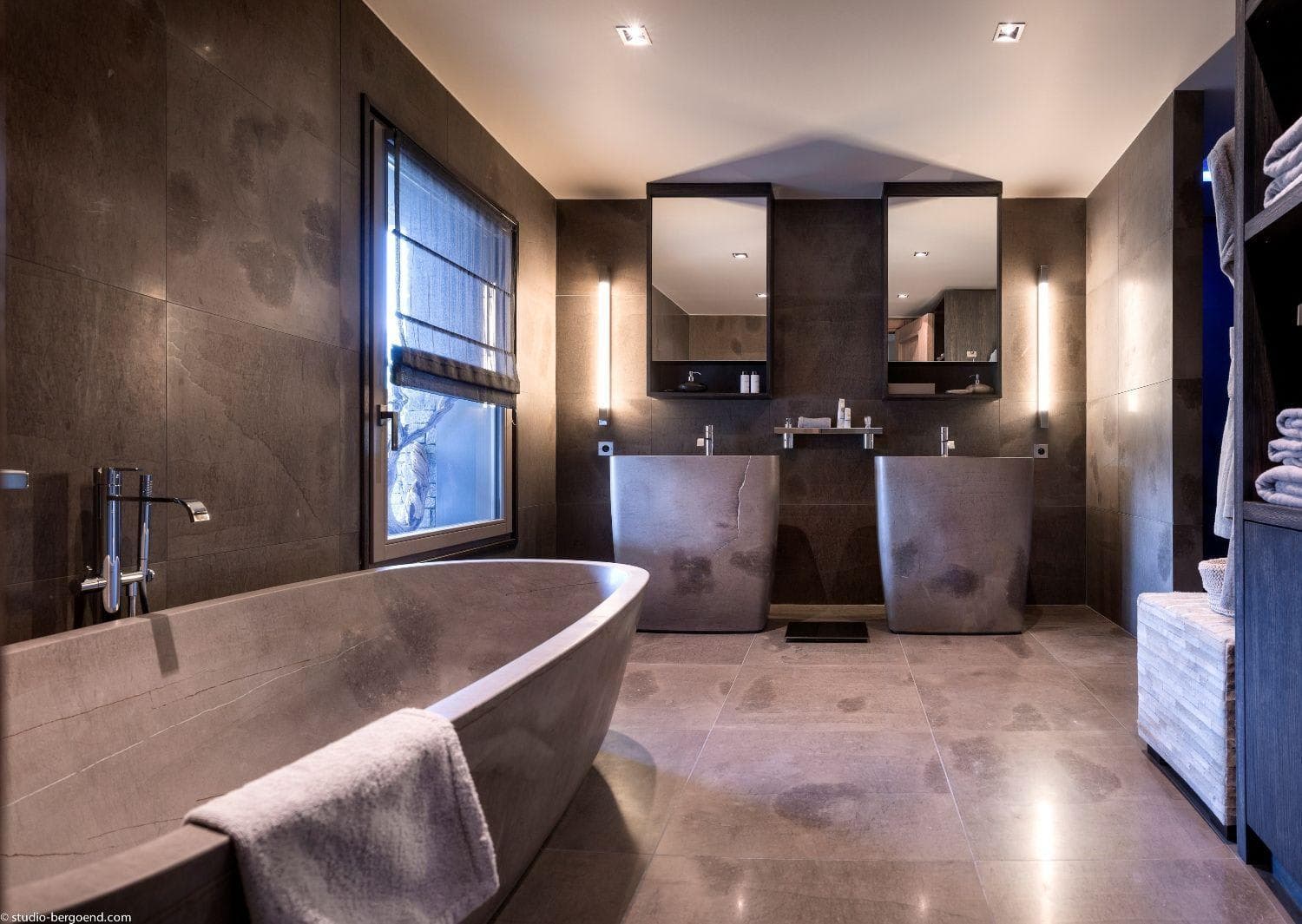 Bathroom with dual stone vanities and freestanding soaking tub