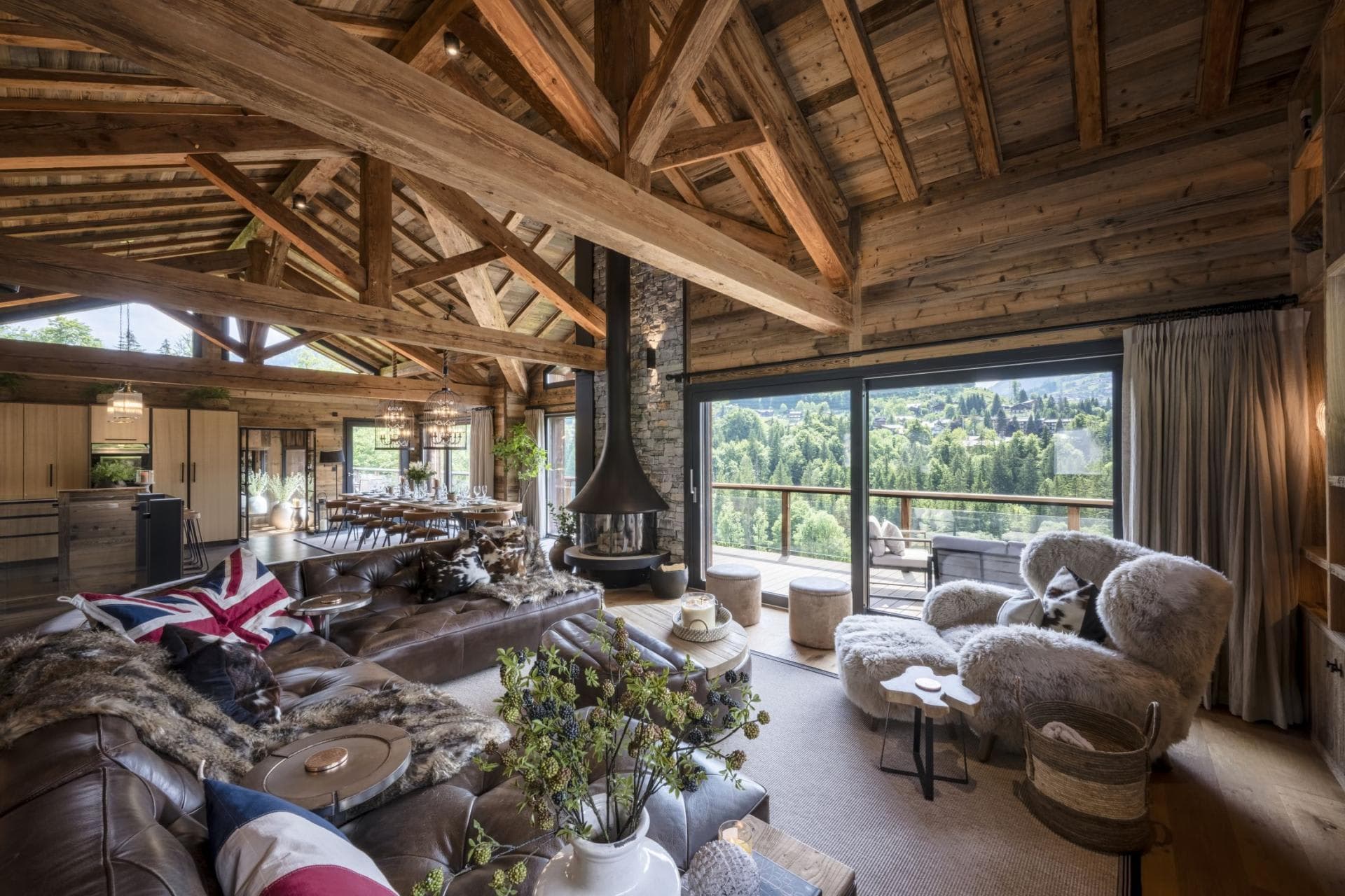 Open-plan living area with suspended fireplace and valley-view terrace