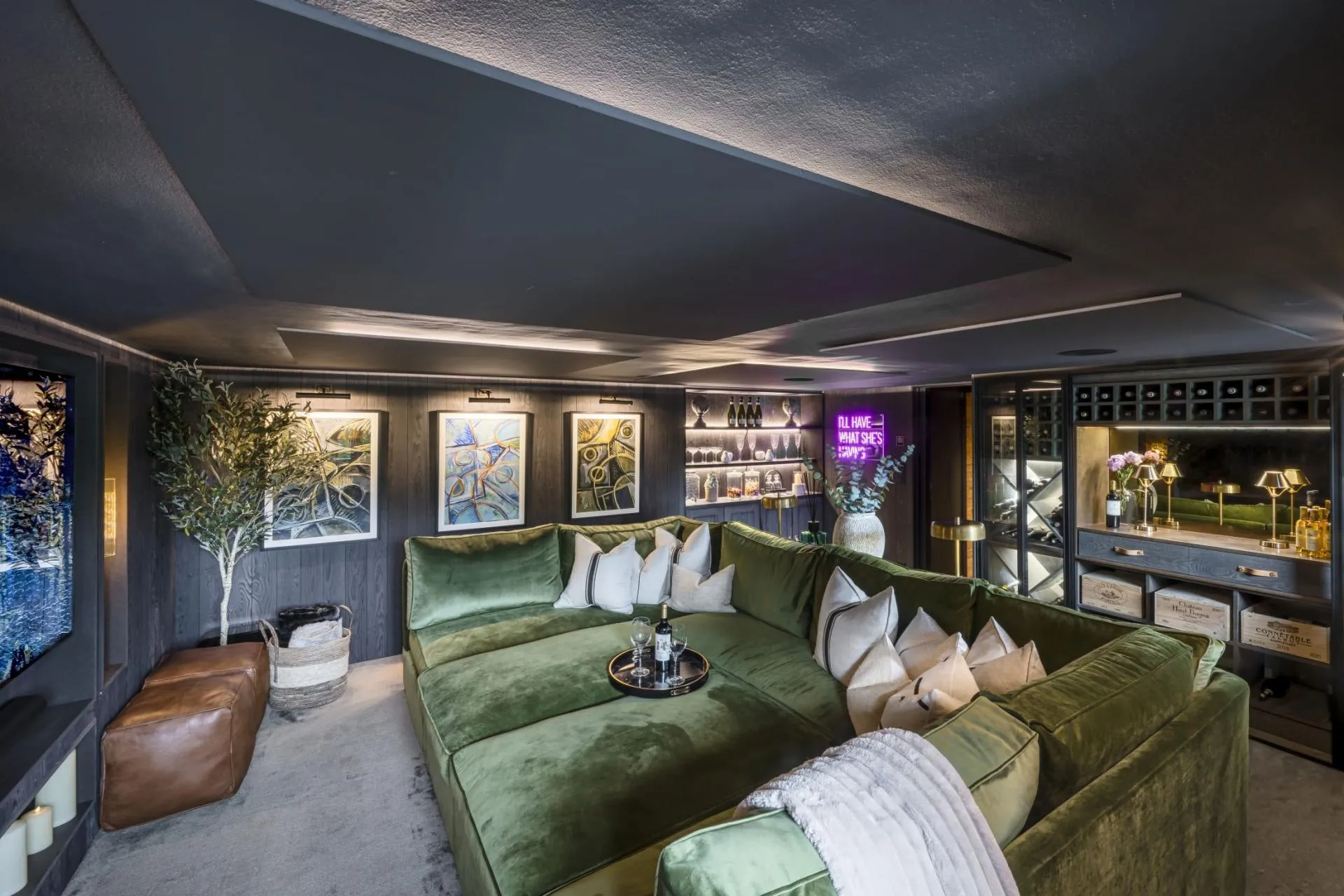 Cinema room with a large screen, sofa and illuminated wine display