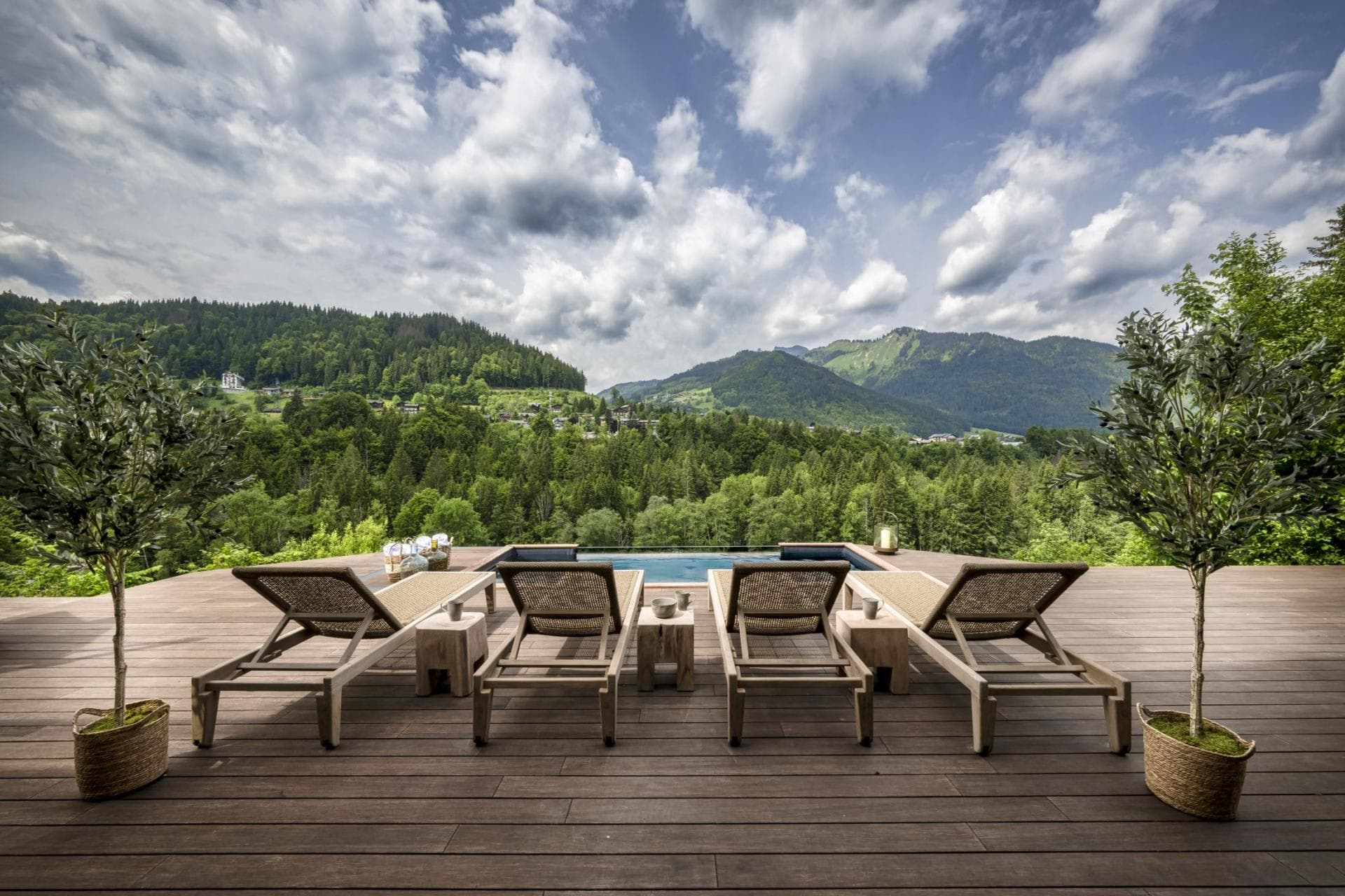 Pool deck with four sun loungers and mountain valley views