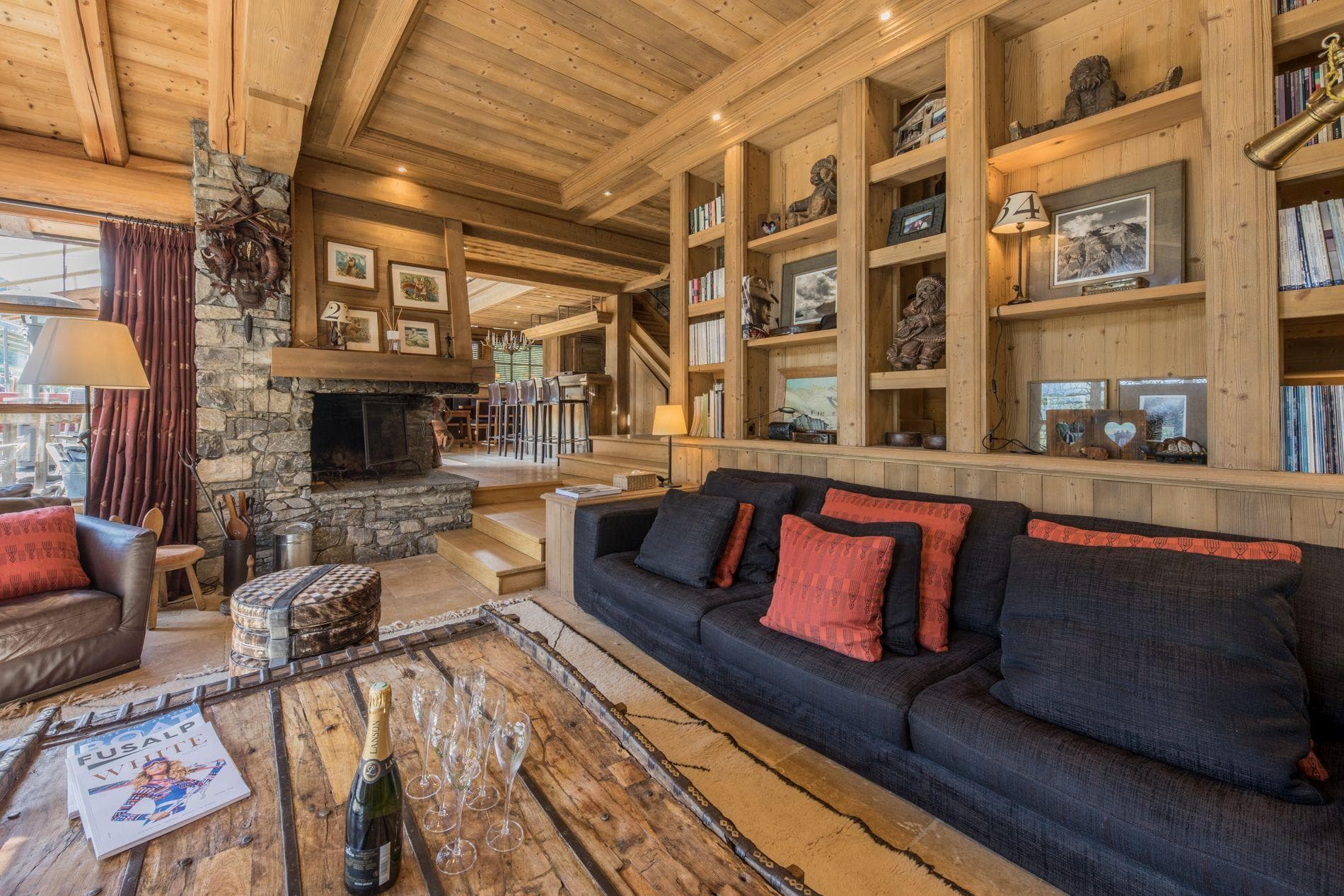 Living area with wood-burning fireplace and floor-to-ceiling library shelving