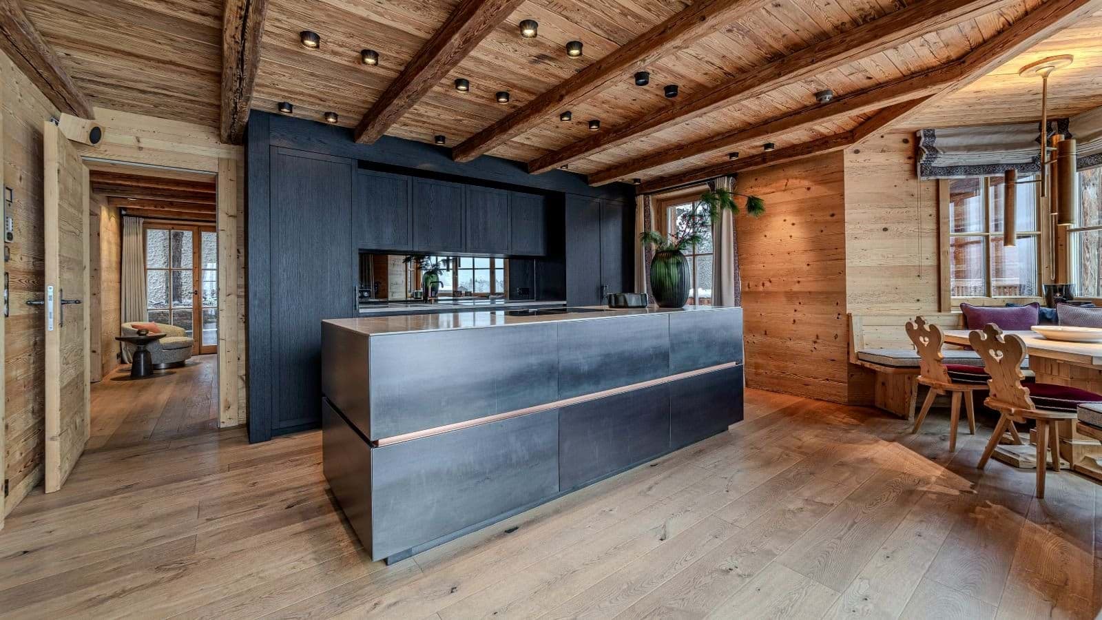 Kitchen with metal-clad island and reclaimed wood ceiling; dining nook adjacent