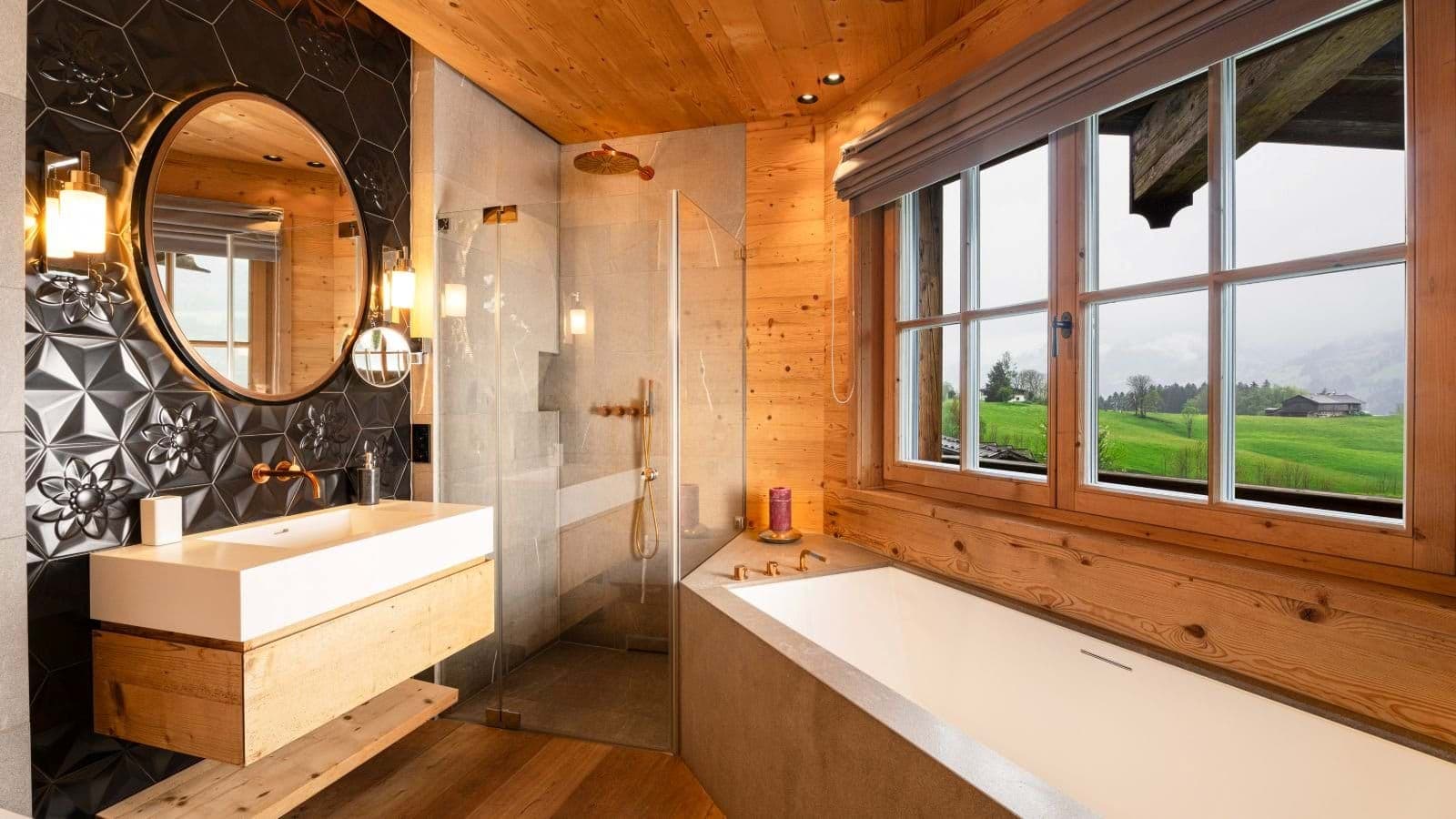 Bathroom with walk-in rainfall shower, soaking tub, and meadow views