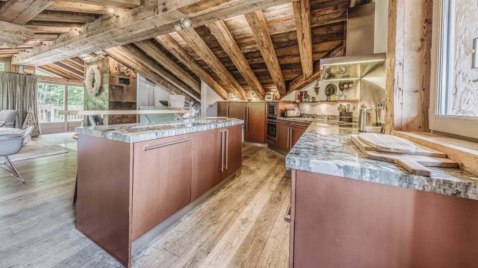 Kitchen with double wall ovens and stone-topped breakfast island