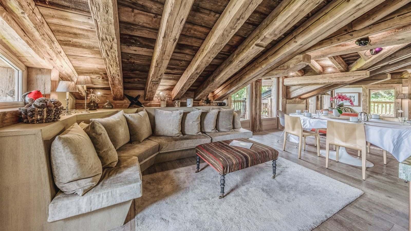 Open-plan living area with original timber beams and built-in sectional seating