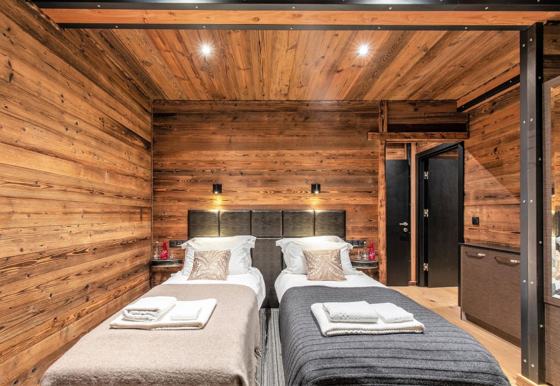 Guest bedroom with two twin beds and reclaimed wood paneling