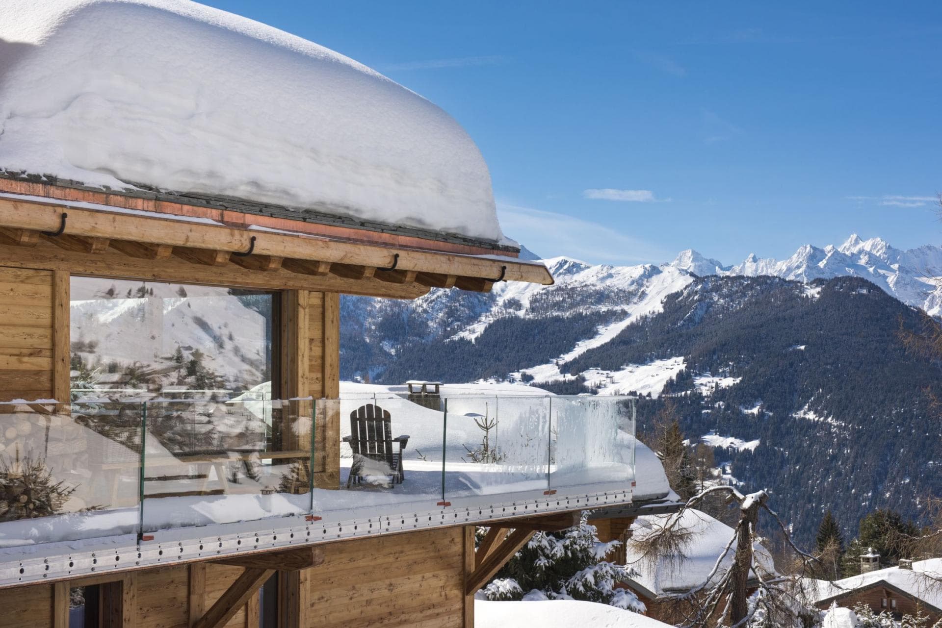 Private balcony with glass railings and panoramic mountain views