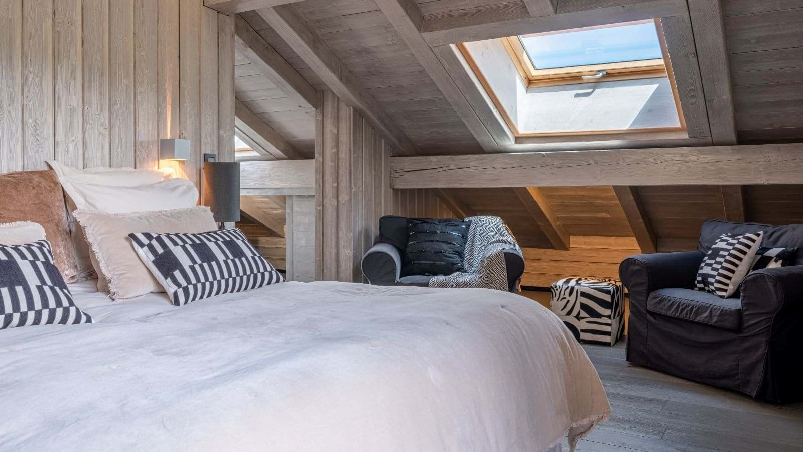 Attic bedroom with seating area and operable skylight