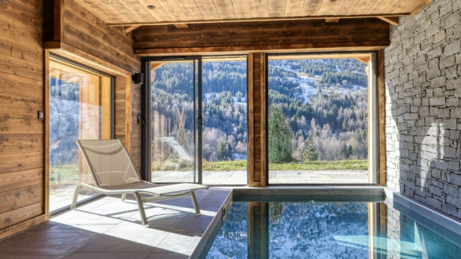 Indoor pool with floor-to-ceiling windows and mountain views