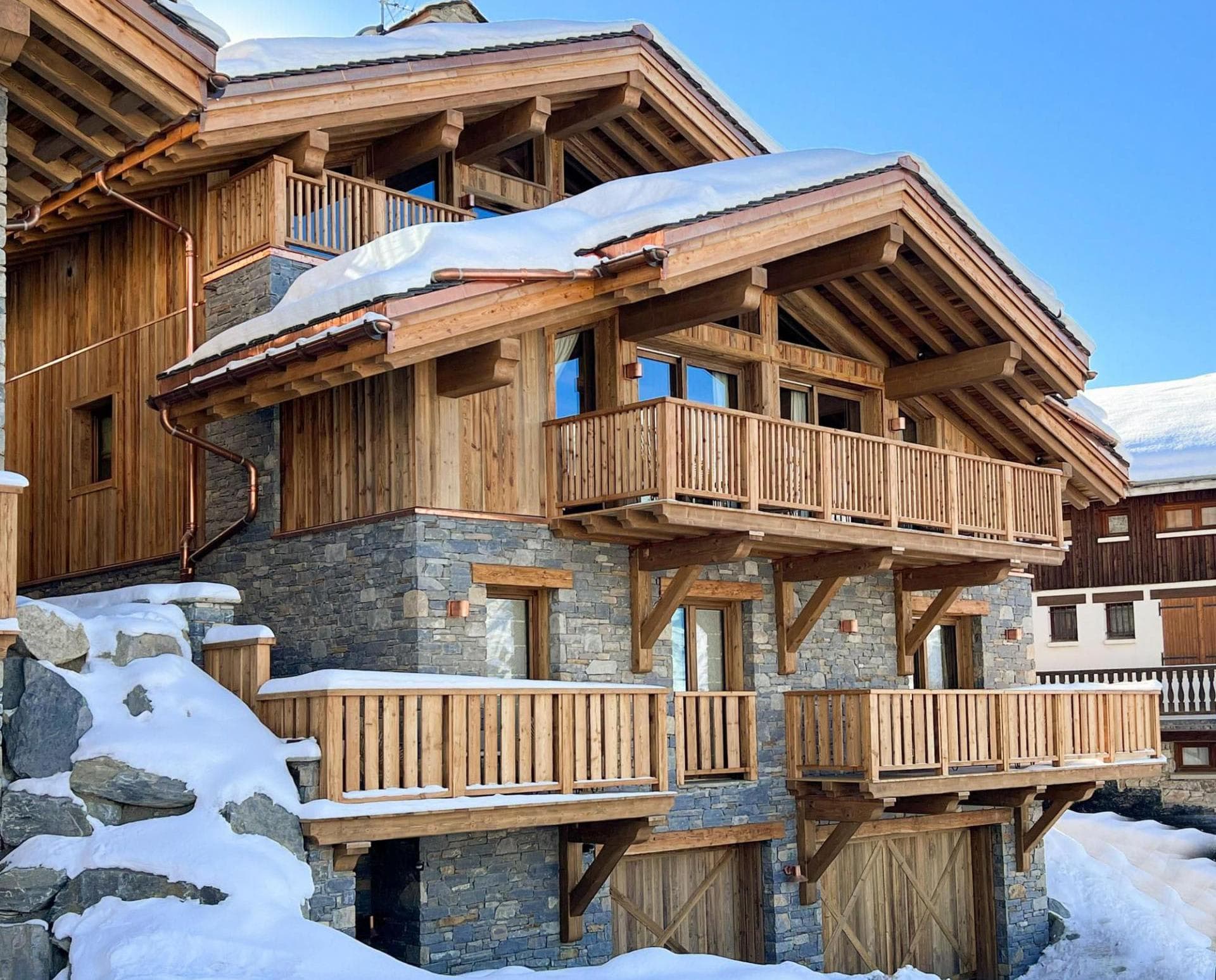 Chalet exterior with stone facade and private balconies for multiple levels