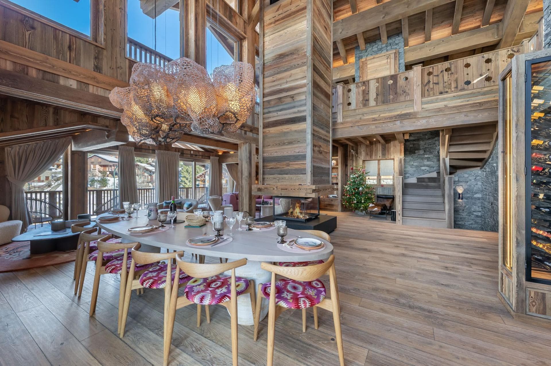 Dining area seating 10 with central glass fireplace and mountain views