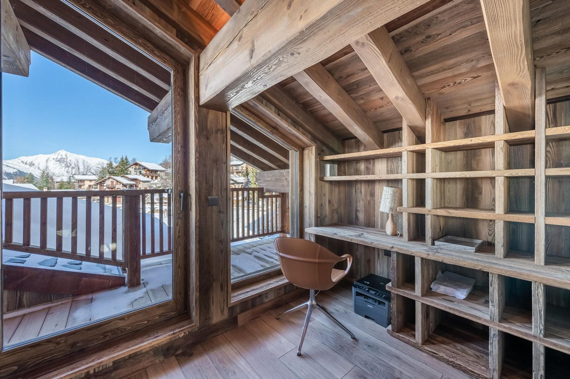 Office nook with built-in desk, printer, and mountain-view balcony access