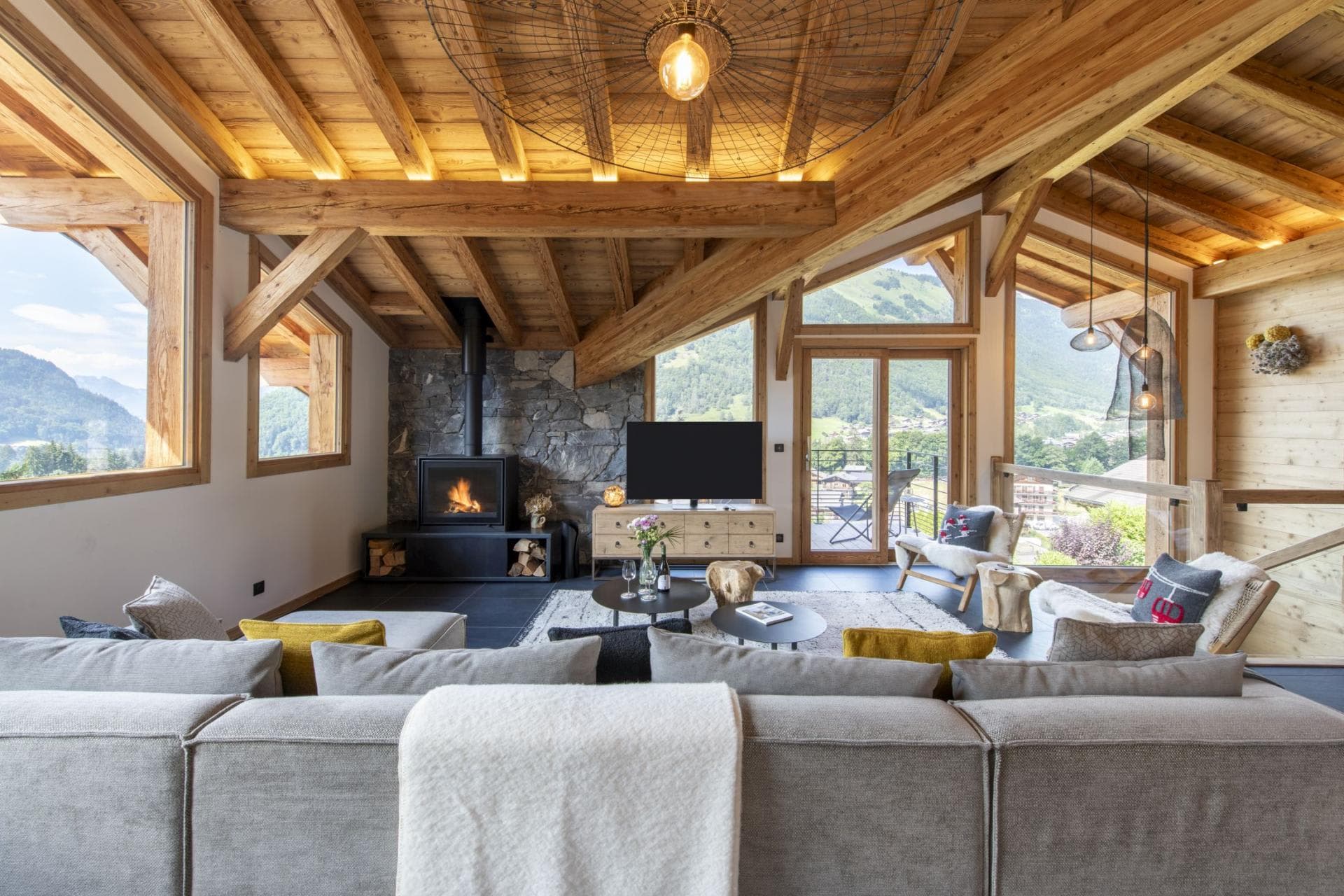 Living area with wood-burning stove and balcony access to valley views