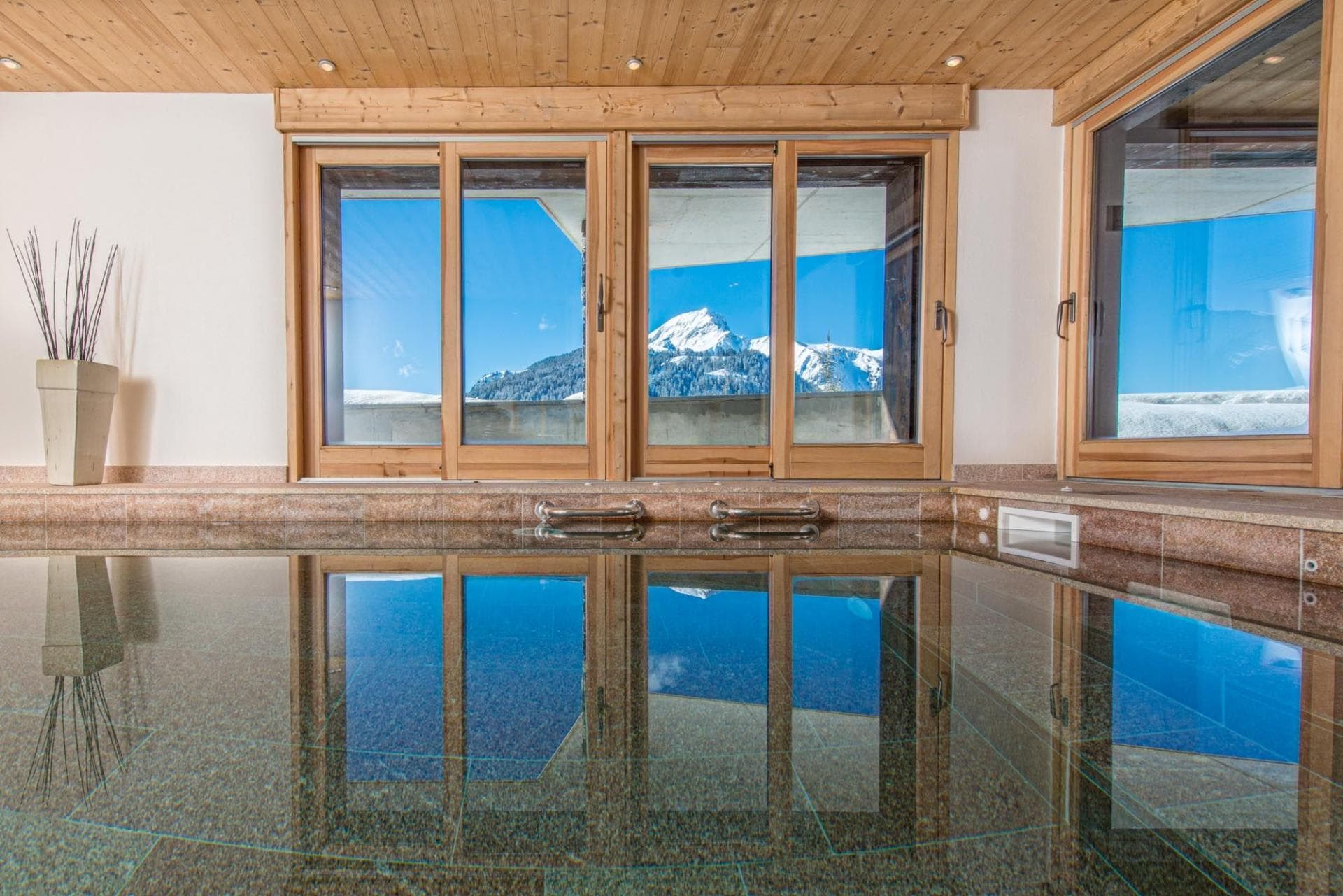 Indoor swimming pool with stone tile and mountain peak views