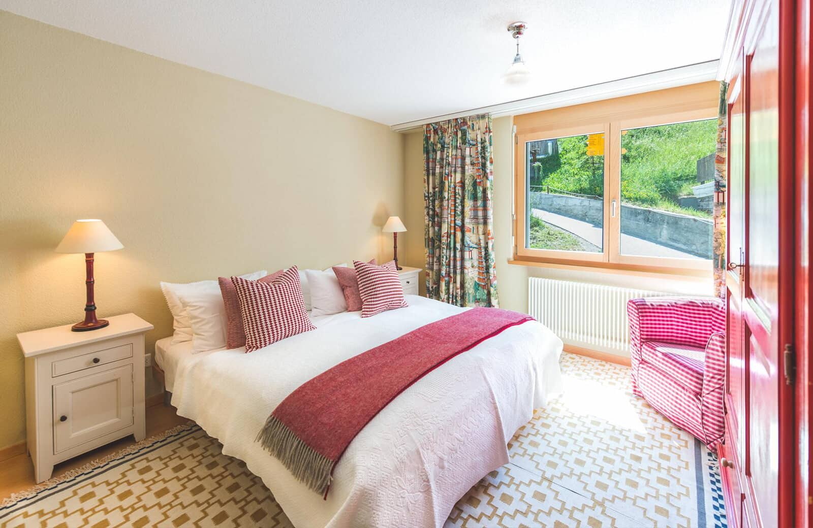 Bedroom with king bed and hillside views through large window
