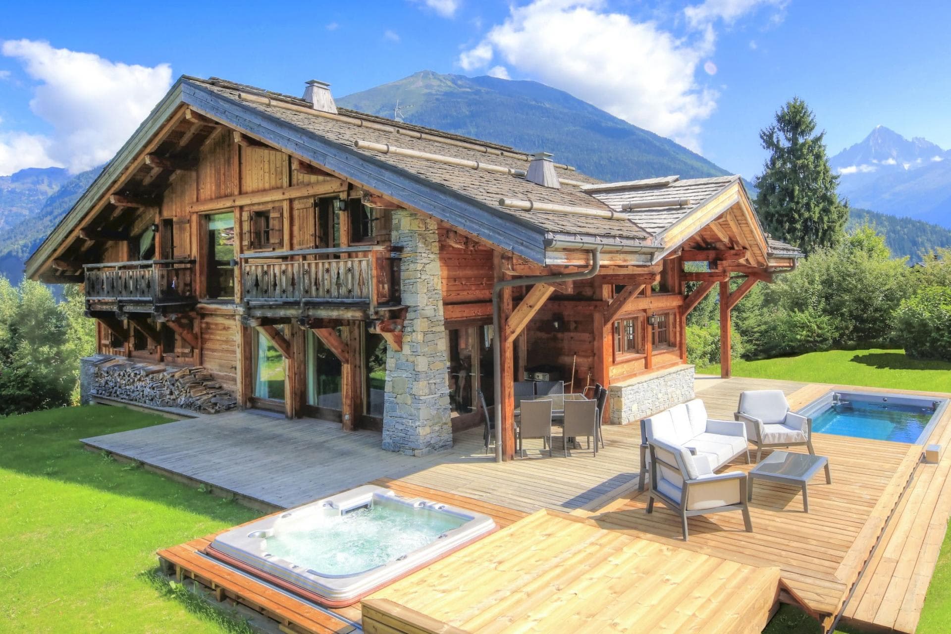 Chalet terrace with heated pool, hot tub, and mountain views