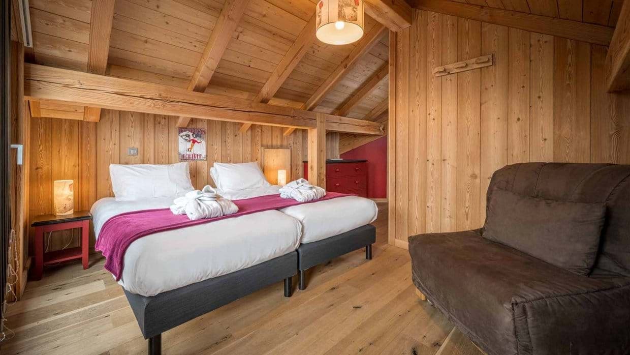 Attic bedroom with vaulted timber ceilings and twin beds