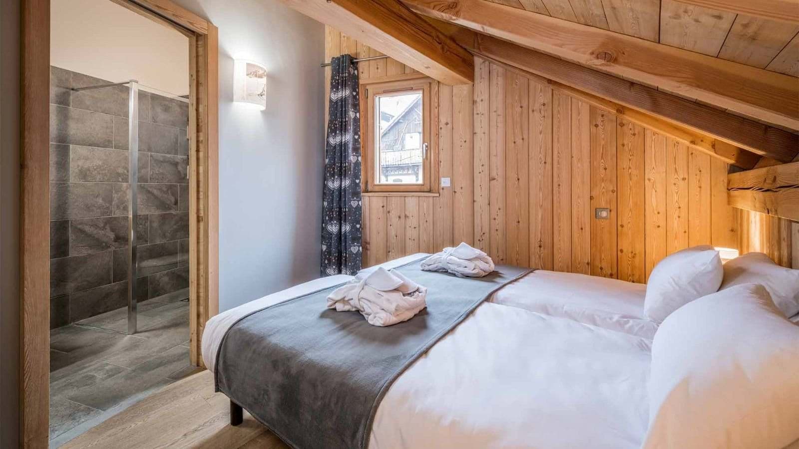 Attic bedroom with wood-paneled walls and ensuite walk-in shower