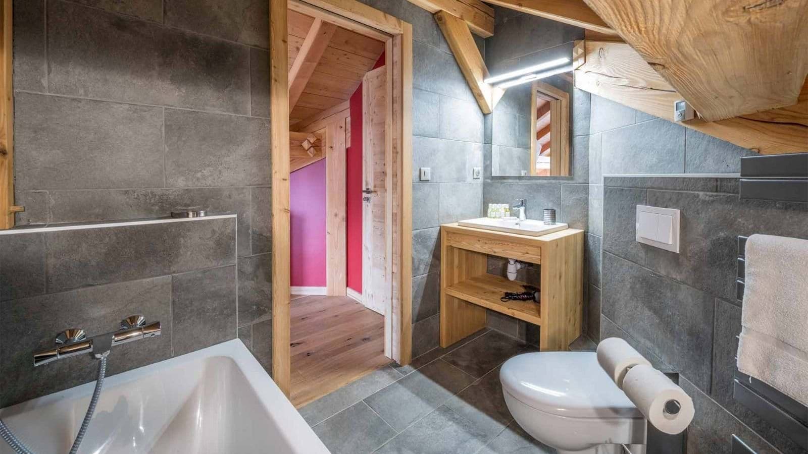 Full bathroom with bathtub and exposed wood beams