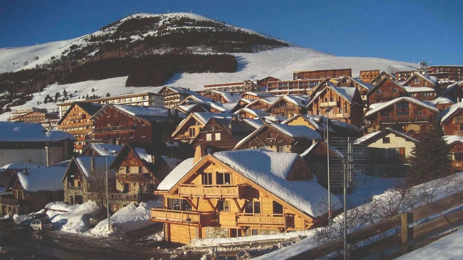 Alpine village view with traditional timber chalets and mountain backdrop