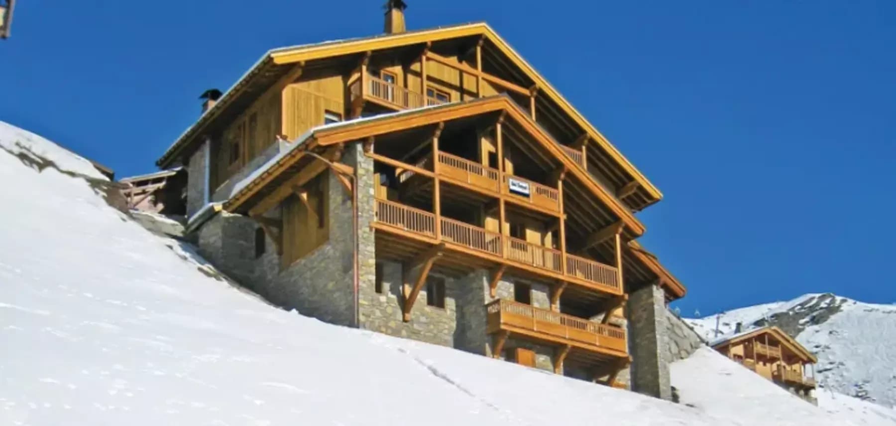 Timber and stone chalet with multi-level balconies and slope-side location