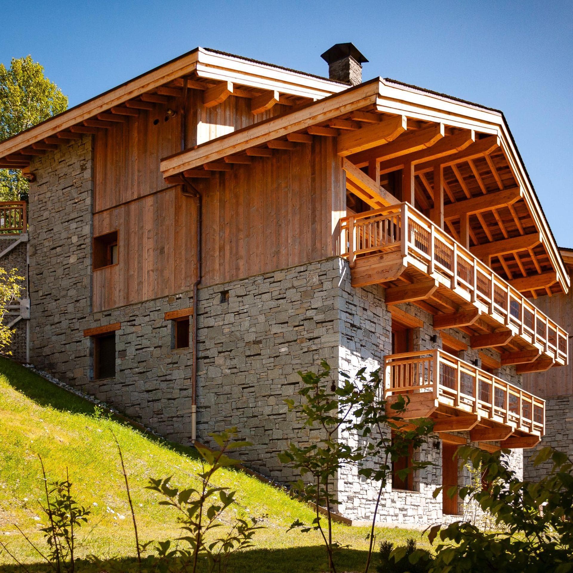 Chalet exterior with stone masonry and private balconies on every level