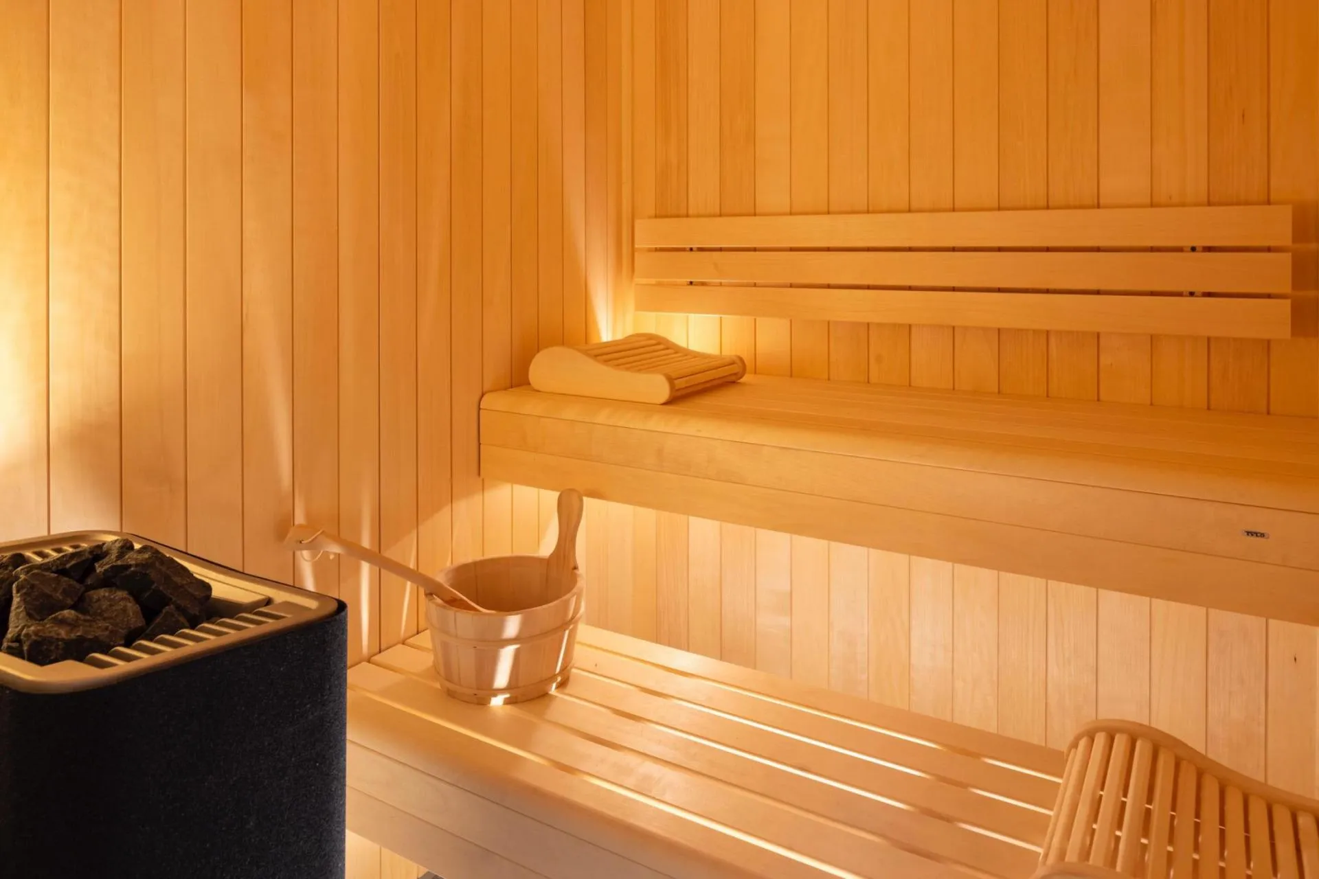 Timber sauna with heated benches and stove