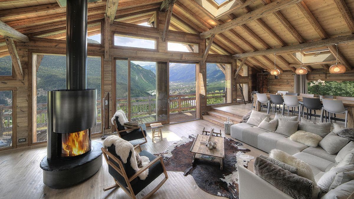 Living area with wood-burning stove and floor-to-ceiling valley views