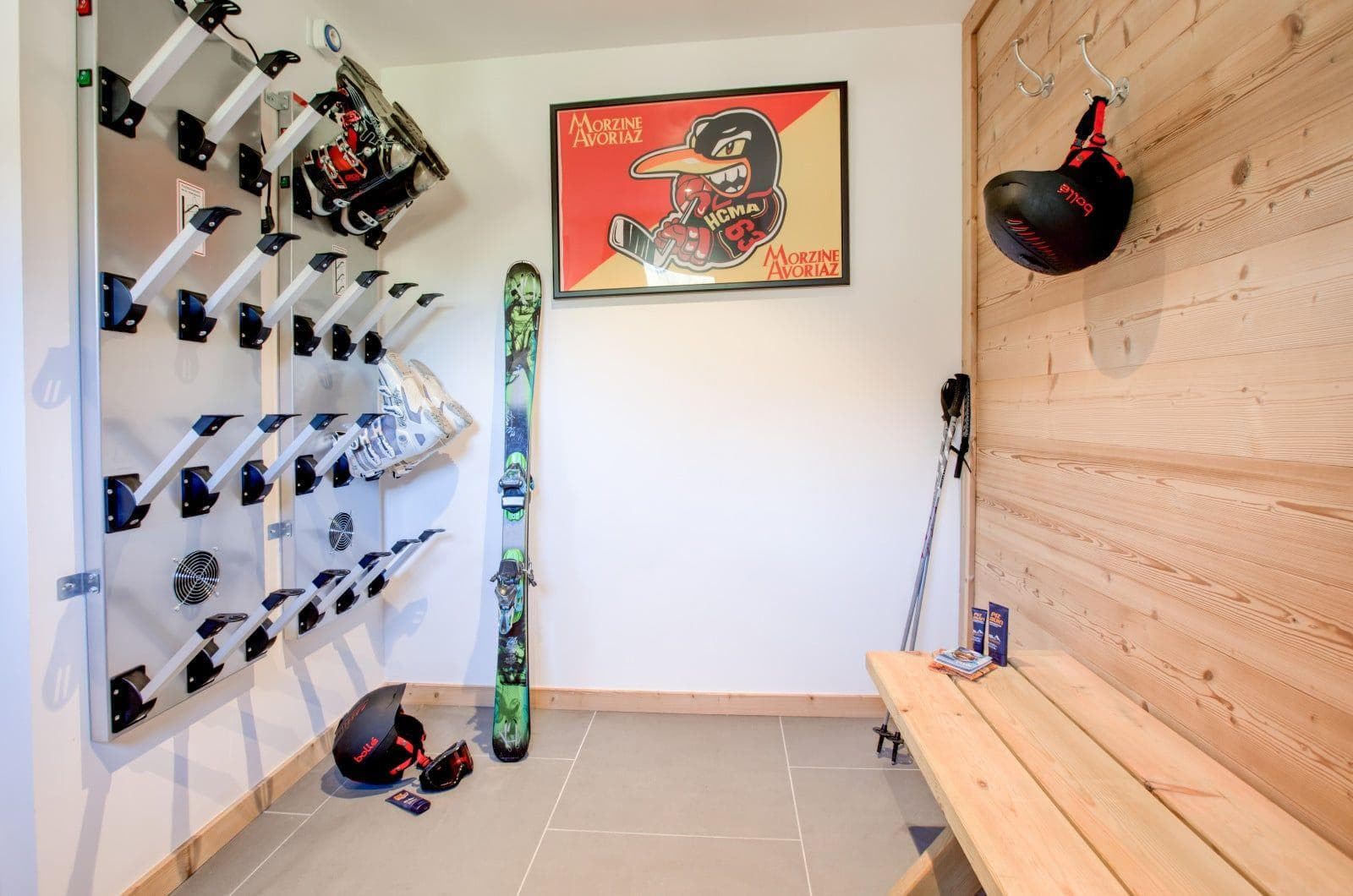 Ski room with heated boot rack, bench seating, and gear hooks