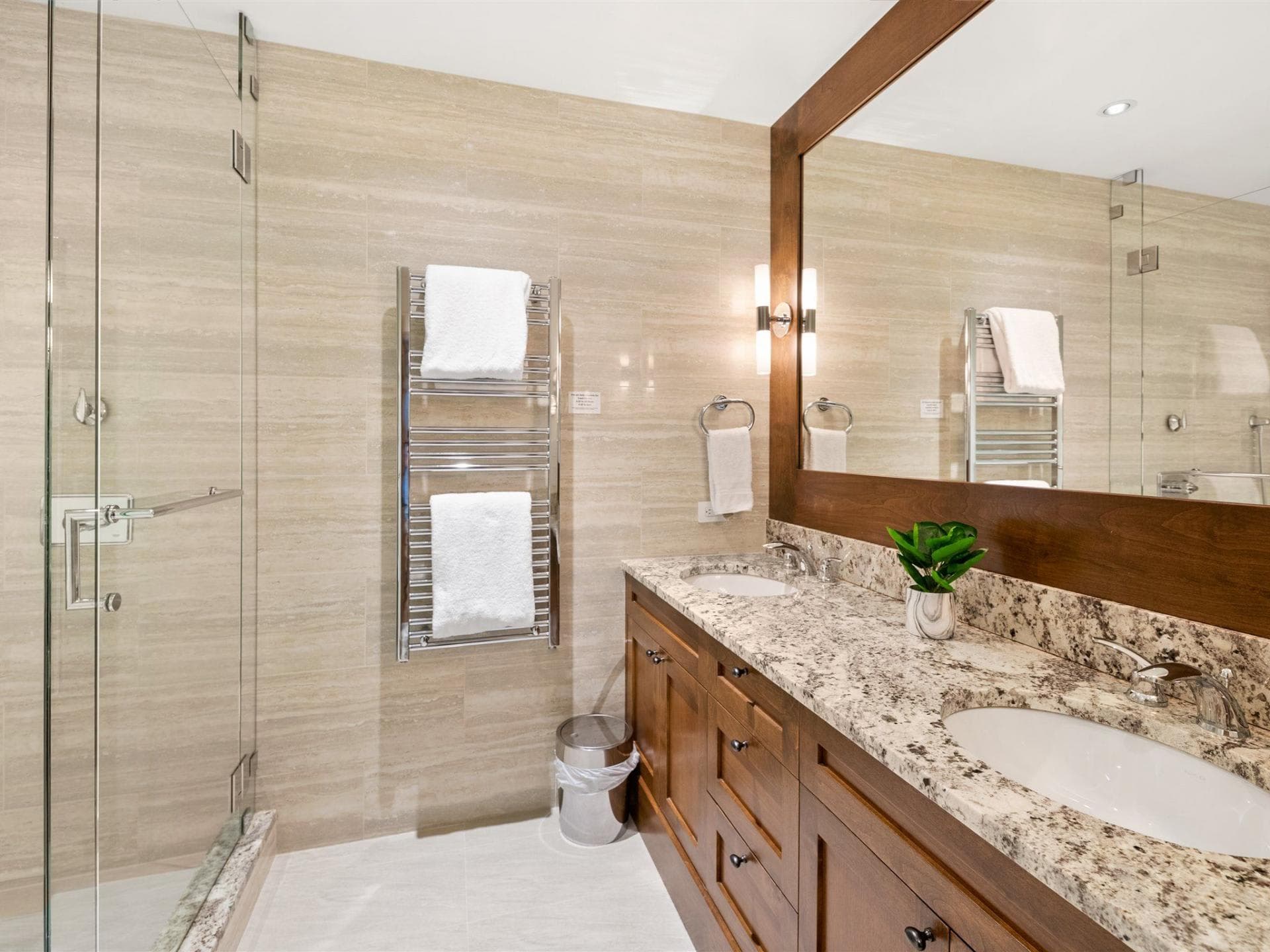Bathroom with dual vanity, granite counters, and heated towel rack