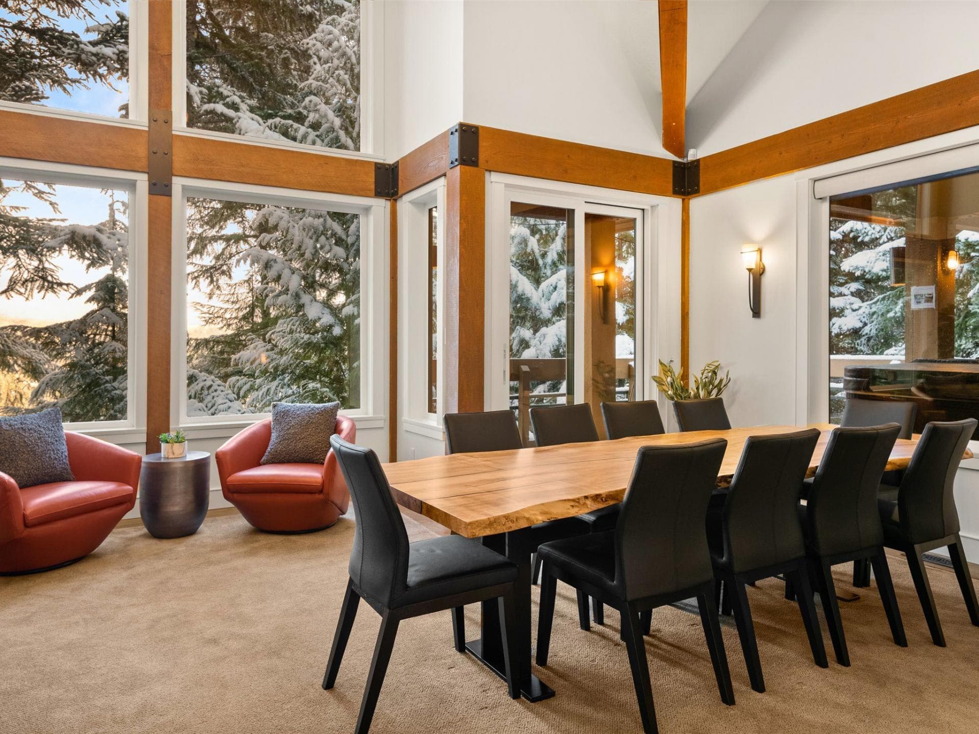 Dining area seats 10; live-edge table and floor-to-ceiling forest views