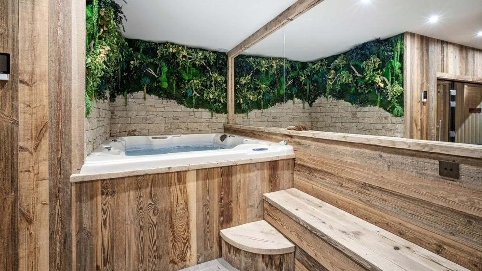 Indoor hot tub with living moss wall and dry sauna access