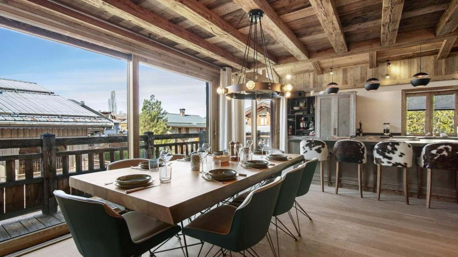 Dining table seats 8; floor-to-ceiling windows with mountain village views