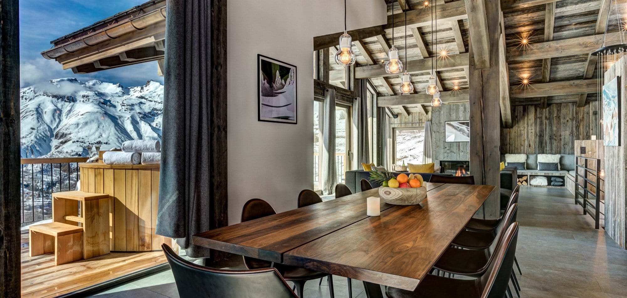Open-plan dining area with terrace access and mountain-view hot tub
