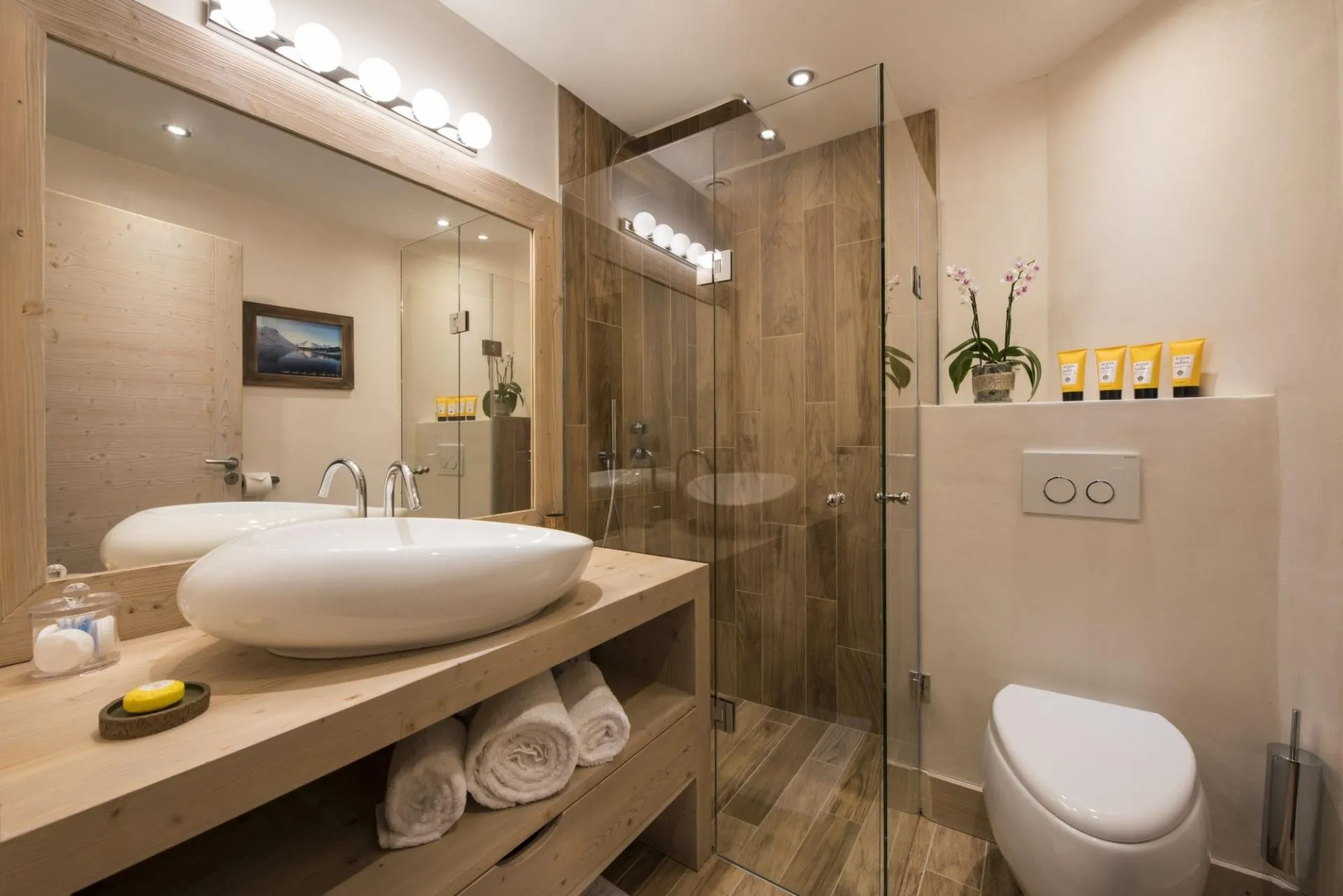 Bathroom with vessel sink and glass-enclosed walk-in rainfall shower