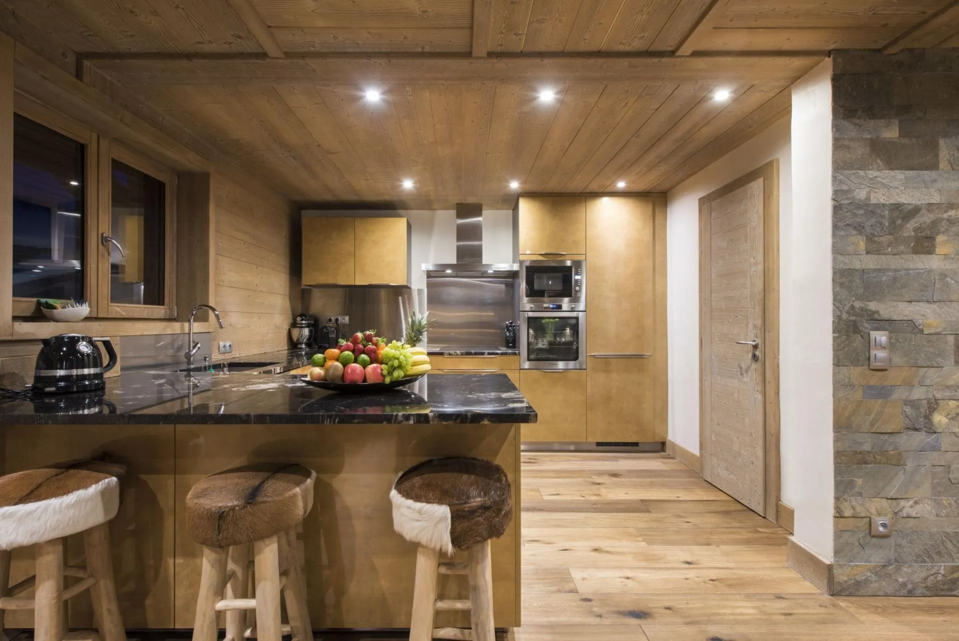 Kitchen with wall-mounted double oven and breakfast bar seating for 3