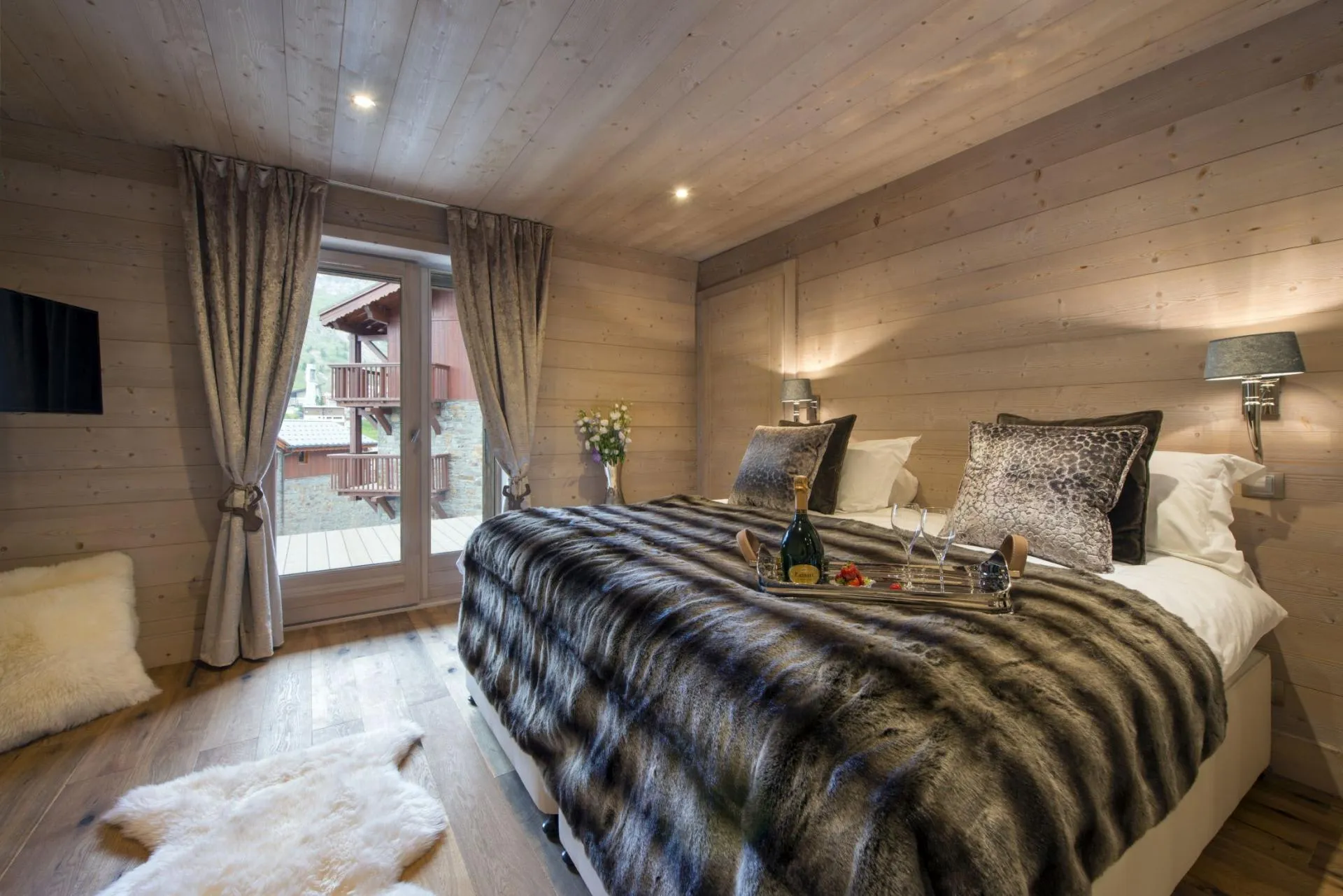 Wood-paneled bedroom with terrace access and village views