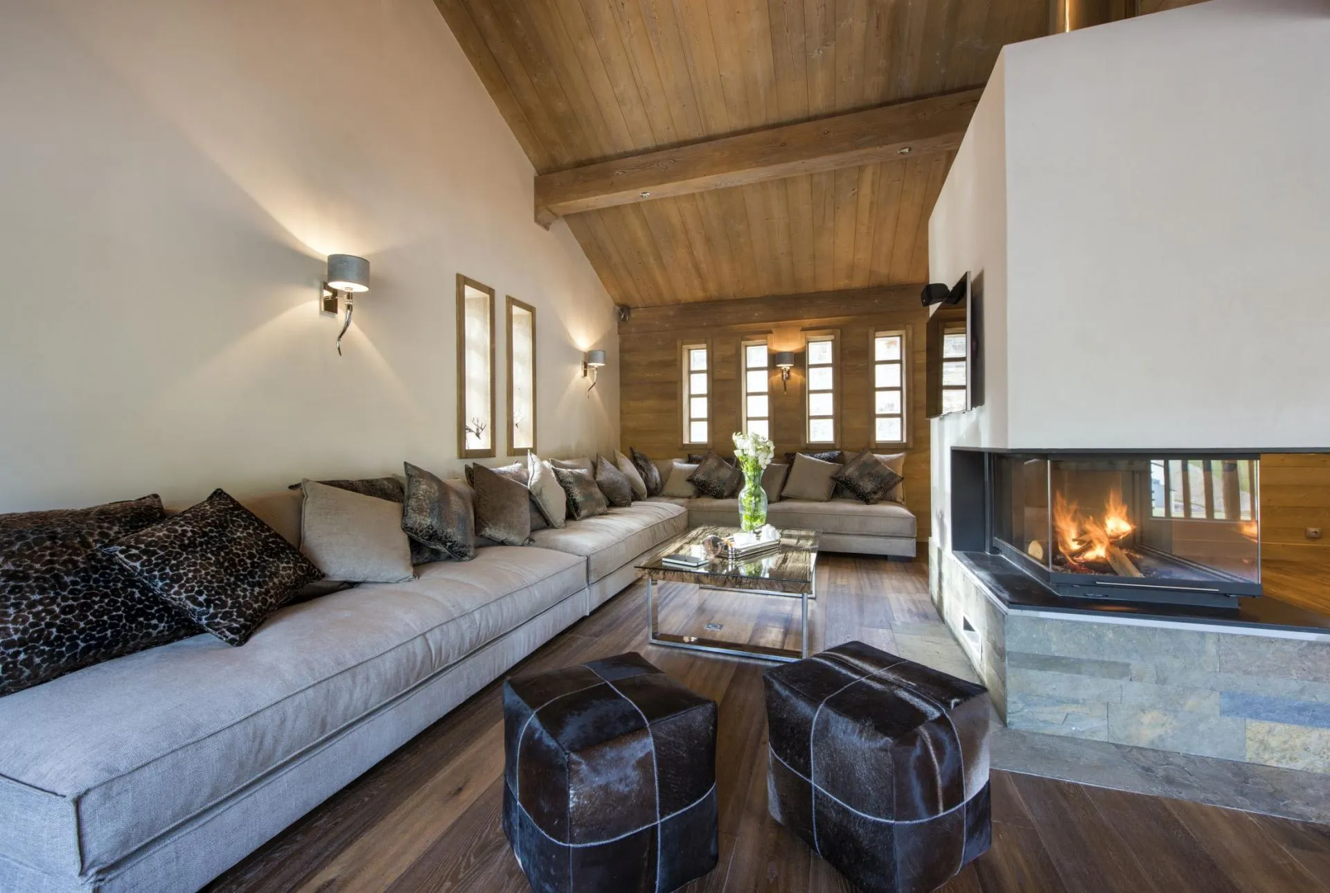 Living area with wood-burning fireplace and wrap-around sofa seating