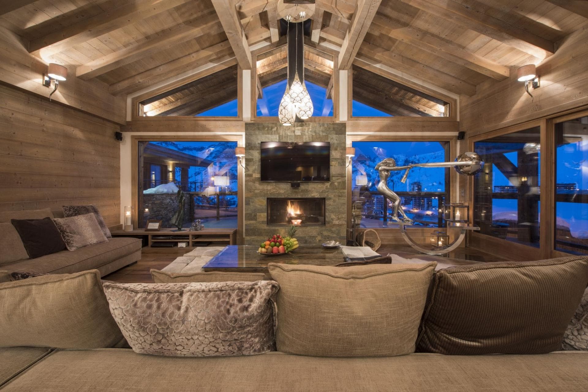 Living area with wood-burning fireplace and floor-to-ceiling mountain views