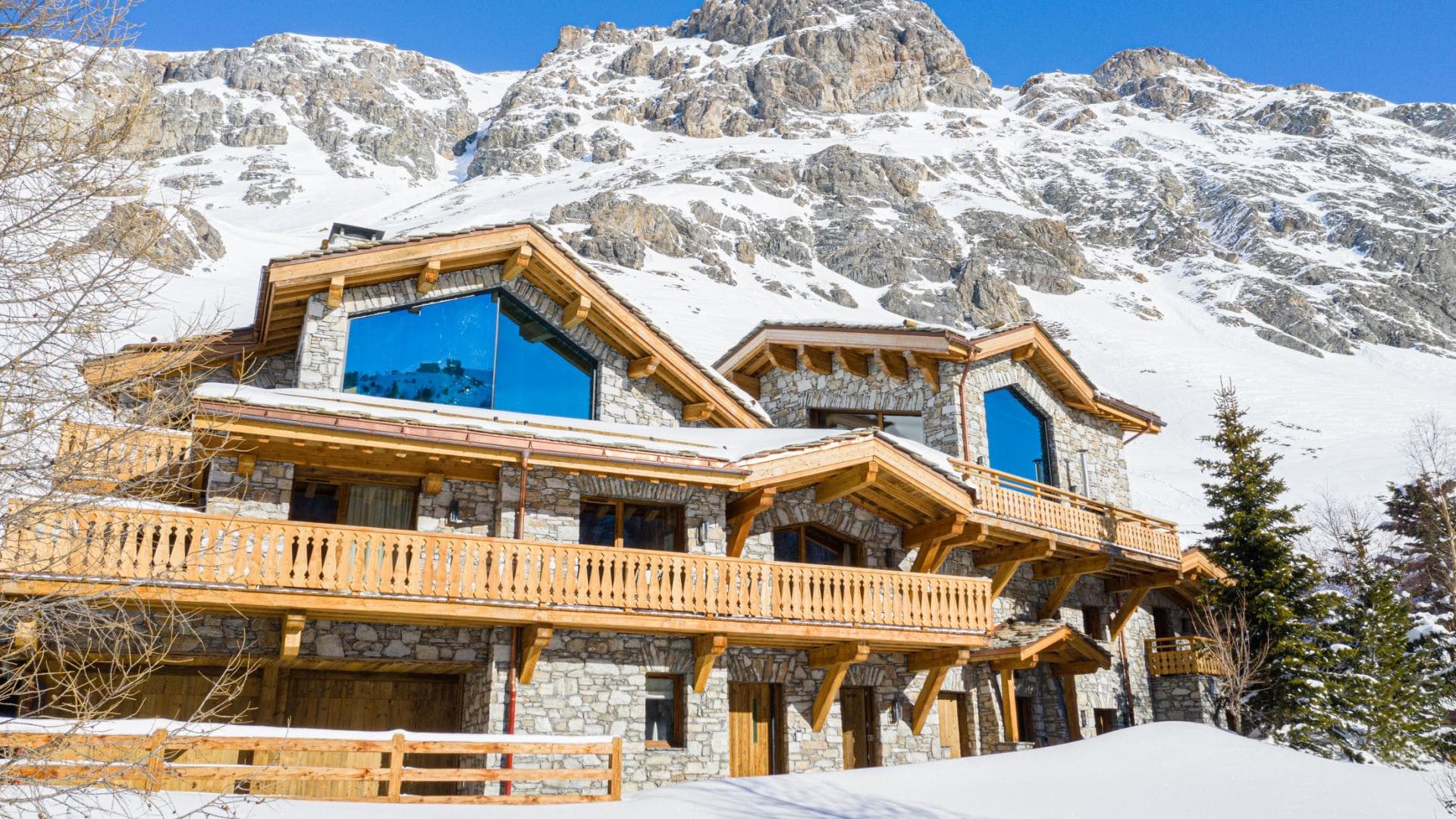 Ski-in chalet exterior with stone masonry and private balconies